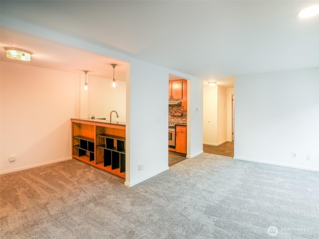 carpeted living room with baseboards and a sink