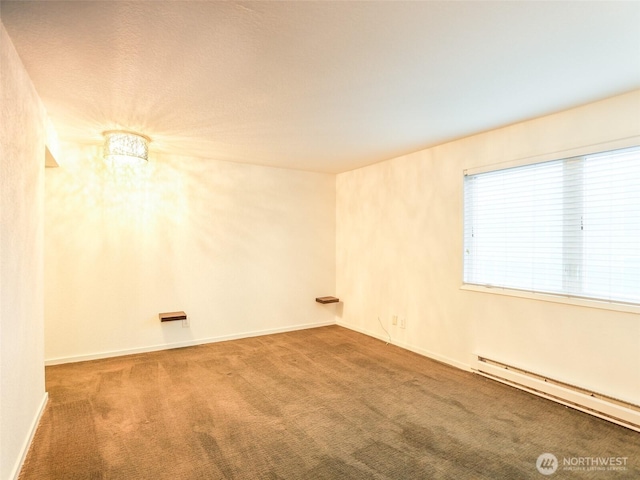 spare room featuring baseboards, a baseboard heating unit, and carpet flooring