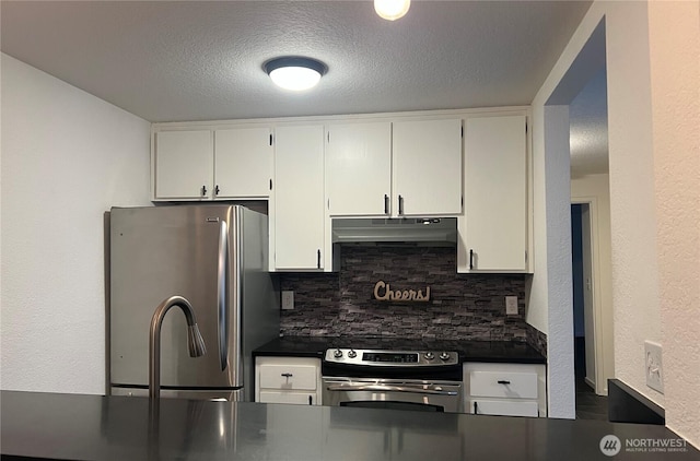 kitchen featuring dark countertops, under cabinet range hood, white cabinetry, and stainless steel appliances