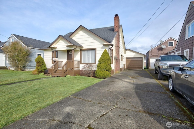 view of front of home with aphalt driveway, an outdoor structure, a front yard, a shingled roof, and a chimney