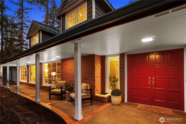 property entrance featuring a garage and brick siding