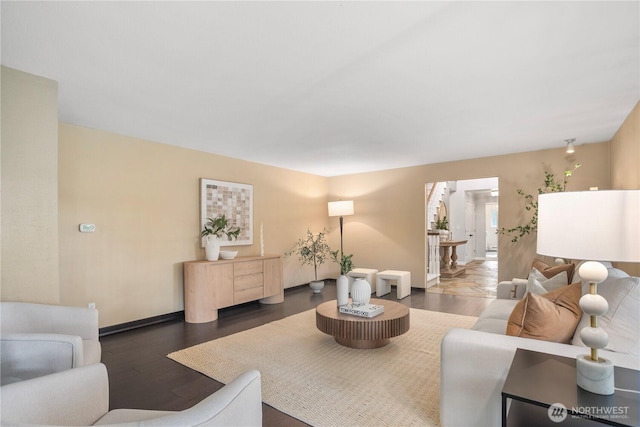 living area with baseboards and wood finished floors