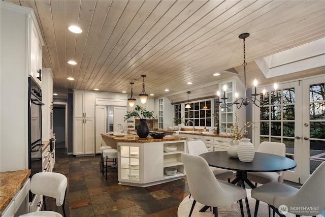 dining space with stone tile floors, wood ceiling, and recessed lighting