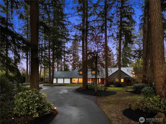 view of front of house featuring metal roof, aphalt driveway, and a standing seam roof