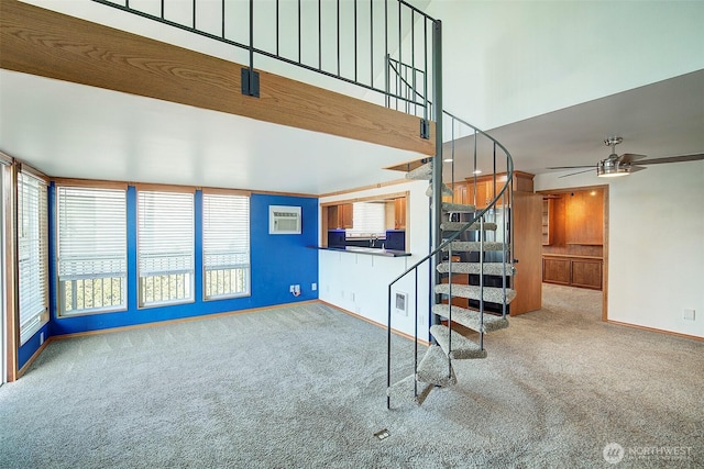 unfurnished living room featuring a ceiling fan, carpet, an AC wall unit, and stairs