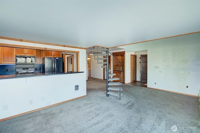 kitchen featuring light carpet, visible vents, dark countertops, brown cabinets, and stainless steel appliances