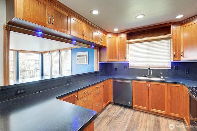 kitchen with a sink, dishwasher, light wood finished floors, brown cabinetry, and dark countertops