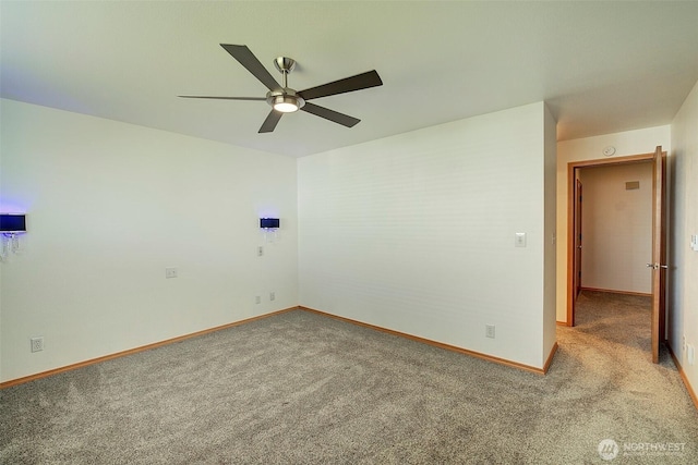 empty room with carpet flooring, a ceiling fan, and baseboards