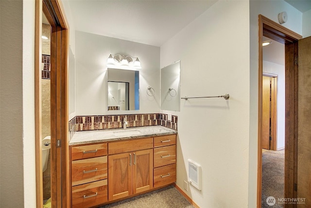 bathroom featuring visible vents, decorative backsplash, and vanity