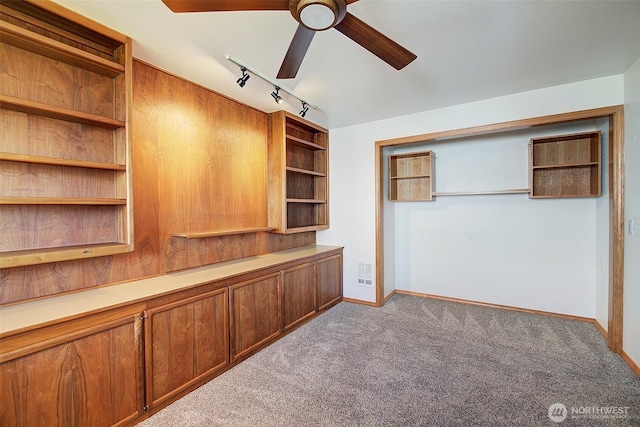 interior space featuring ceiling fan, carpet flooring, visible vents, baseboards, and rail lighting