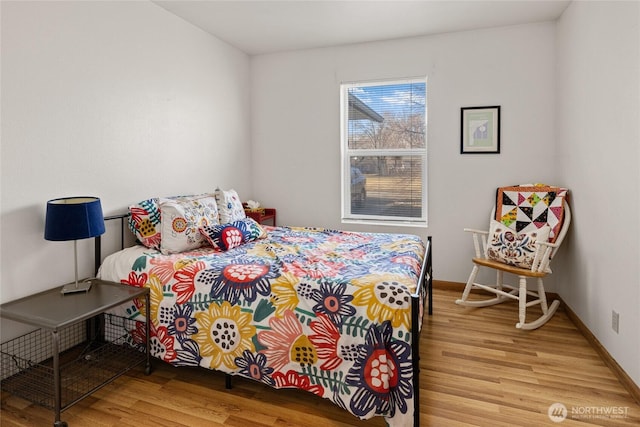 bedroom with light wood finished floors and baseboards