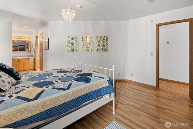 bedroom with light wood finished floors, baseboards, connected bathroom, a chandelier, and a sink