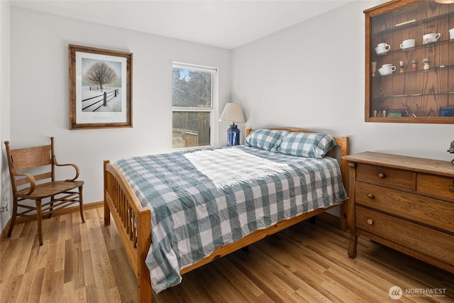 bedroom featuring light wood-style flooring and baseboards