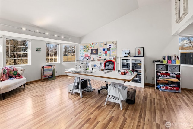 office featuring high vaulted ceiling, baseboards, and wood finished floors