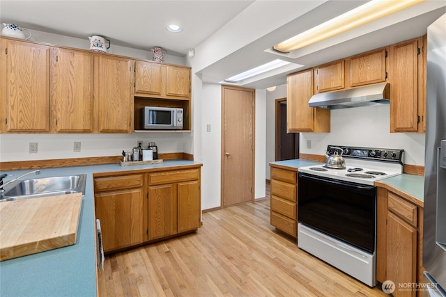 kitchen featuring electric stove, stainless steel microwave, light countertops, light wood-type flooring, and under cabinet range hood