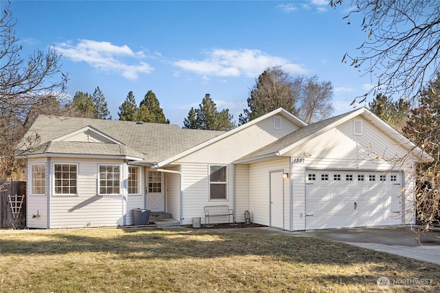 ranch-style home with a garage, concrete driveway, roof with shingles, and a front yard