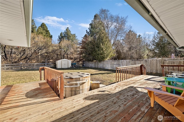 deck featuring a fenced backyard, an outbuilding, a lawn, and a shed