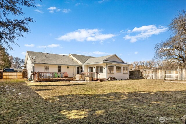 back of property featuring a deck, a yard, and a fenced backyard