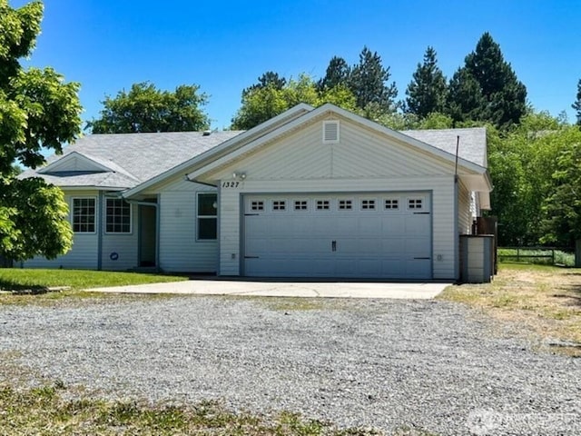 ranch-style home featuring a garage and driveway