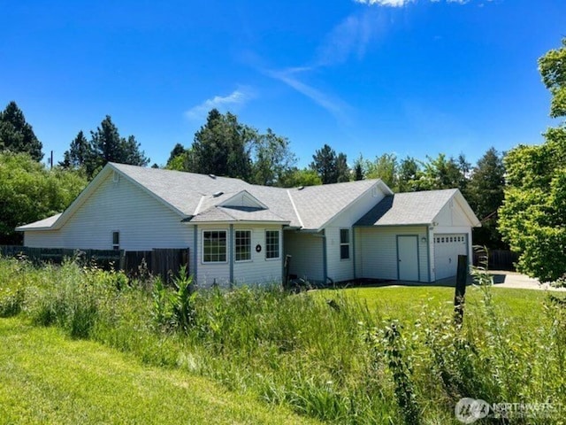 ranch-style home featuring a garage, driveway, and fence