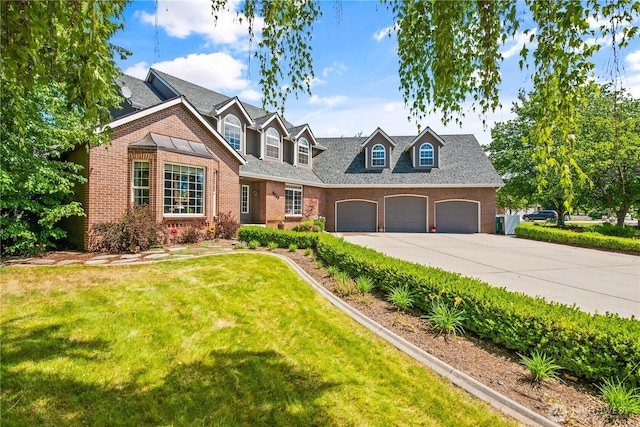 cape cod house with a garage, brick siding, driveway, and a front lawn