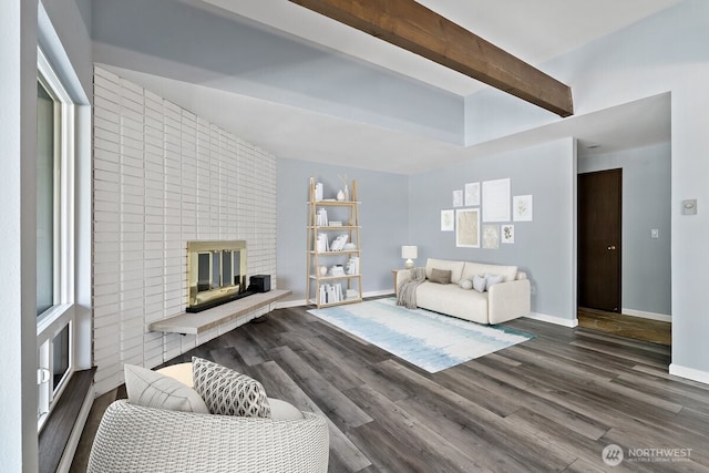 living room featuring a brick fireplace, baseboards, beam ceiling, and wood finished floors