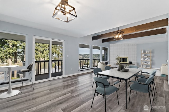 dining room featuring baseboards, beam ceiling, a chandelier, and wood finished floors