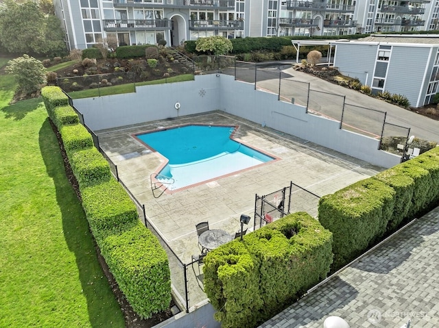 community pool featuring fence and a yard