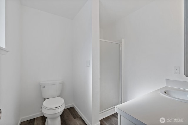 full bathroom featuring baseboards, toilet, wood finished floors, an enclosed shower, and a sink