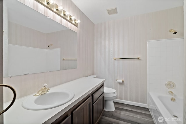 bathroom featuring wallpapered walls, visible vents, toilet, wood finished floors, and vanity