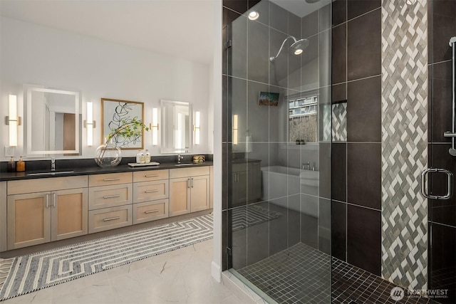 full bathroom featuring double vanity, marble finish floor, a sink, and a stall shower