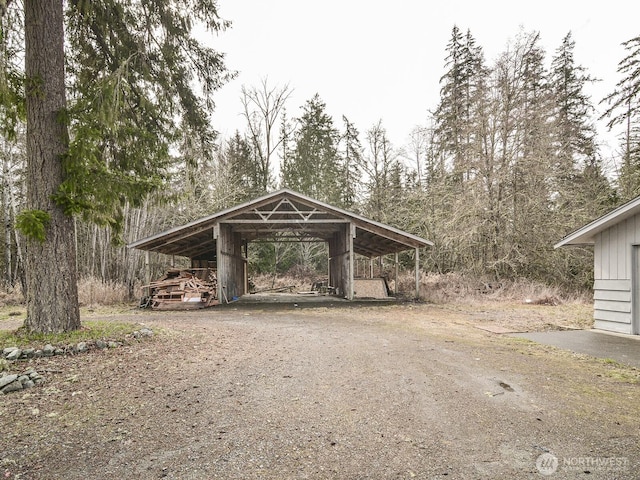 view of home's community with dirt driveway and a carport