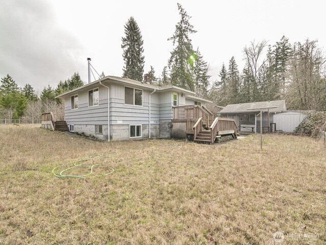 back of property featuring a yard and a wooden deck