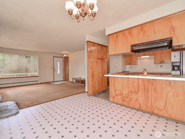 kitchen featuring a chandelier, a baseboard heating unit, light countertops, under cabinet range hood, and refrigerator with ice dispenser