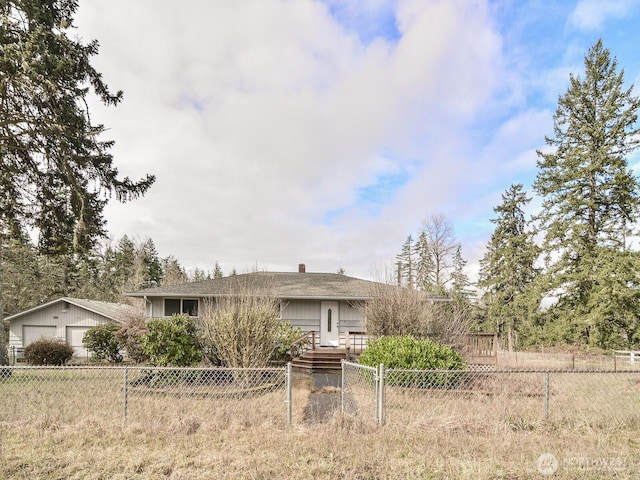 ranch-style house with a fenced front yard, a chimney, and a garage