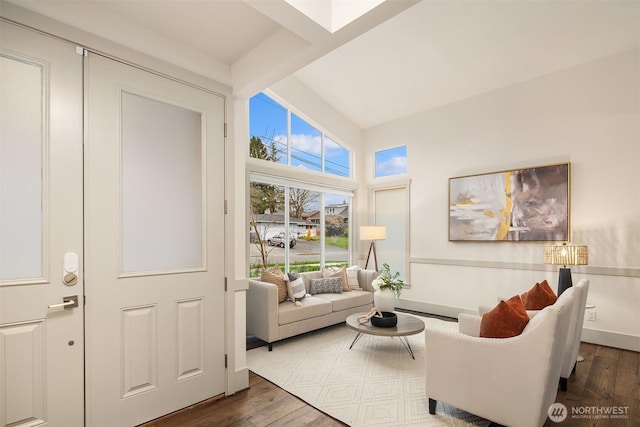 living area with beam ceiling, baseboards, and wood finished floors