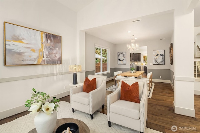 living room featuring baseboards, an inviting chandelier, and wood finished floors