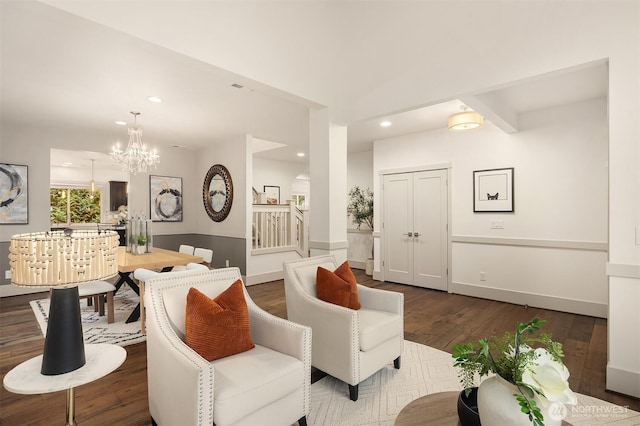 living room with dark wood-style floors, a notable chandelier, recessed lighting, and stairway