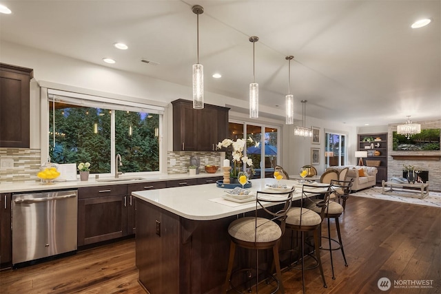 kitchen featuring dark brown cabinetry, dark wood finished floors, dishwasher, and a sink