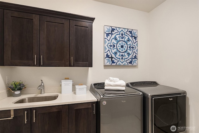 clothes washing area with washing machine and dryer, cabinet space, and a sink