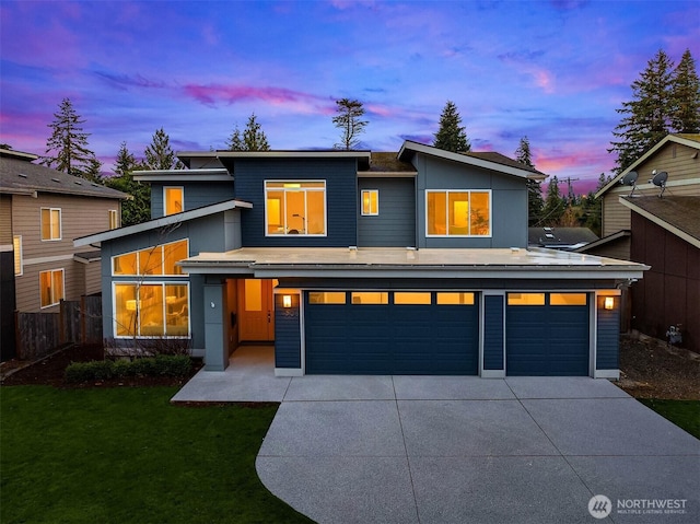 view of front of house with an attached garage, fence, a lawn, and driveway