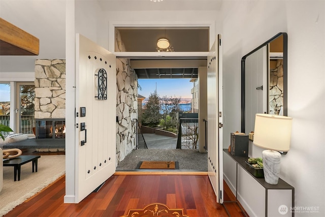 foyer entrance with a fireplace, wood finished floors, and a healthy amount of sunlight