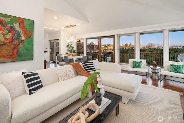 living area featuring recessed lighting, plenty of natural light, a notable chandelier, and wood finished floors