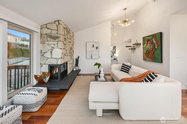 living area featuring baseboards, a fireplace, wood finished floors, a notable chandelier, and high vaulted ceiling