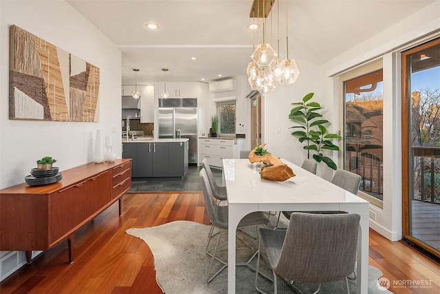 dining space with recessed lighting, dark wood-type flooring, and an AC wall unit