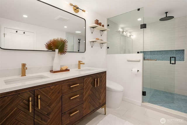 bathroom with a sink, toilet, a stall shower, and double vanity