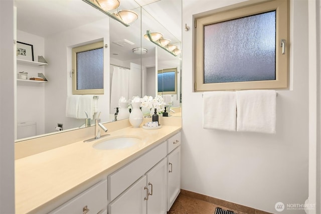 bathroom featuring tile patterned floors, toilet, vanity, and baseboards