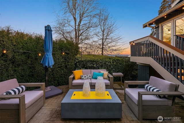 patio terrace at dusk featuring an outdoor hangout area and stairs