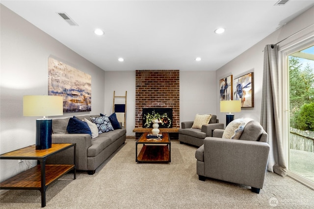 living area with carpet, visible vents, a fireplace, and recessed lighting