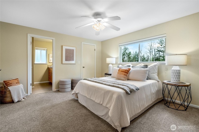 carpeted bedroom featuring a ceiling fan, connected bathroom, and baseboards